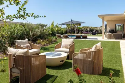 a garden with chairs and a tub on the grass at Faro Luxury Home with Heated Pool and Garden in Faro