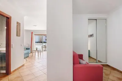 a room with a red couch and a living room at Apartamento 16 - Quarteira in Quarteira
