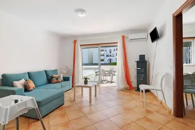 a living room with a blue couch and a table at Apartamento 16 - Quarteira in Quarteira