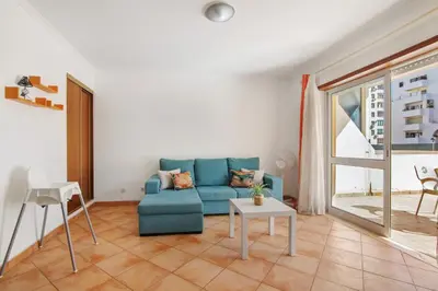 a living room with a blue couch and a table at Apartamento 16 - Quarteira in Quarteira