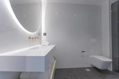 a white kitchen with a table and white chairs at The View at the Downtown 5 in Faro