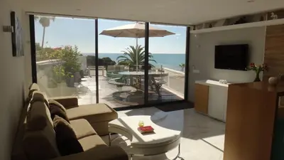 a living room with a couch and a view of the ocean at Fantastic Apartment On The Beach in Albufeira