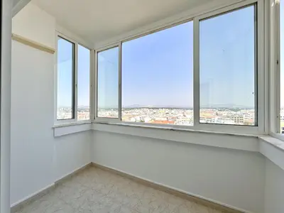 an empty room with white walls and windows at Quarteira Central Beach 5 by Homing in Quarteira
