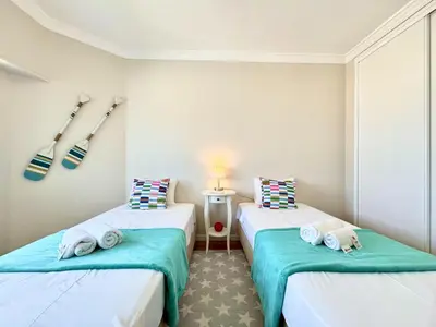 two beds in a room with baseball bats on the wall at Quarteira Central Beach 5 by Homing in Quarteira
