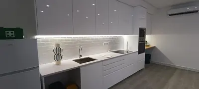 a kitchen with white cabinets and a sink at Skynest 61 Faro Airport Guest House in Faro