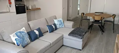 a white couch with blue pillows in a living room at Skynest 61 Faro Airport Guest House in Faro