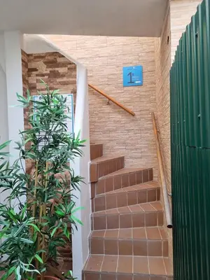 a staircase with a blue sign on a brick wall at Budget Beach Center - B4 in Albufeira