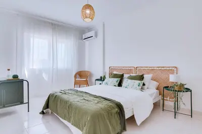 a white bedroom with a bed and a tv at Brisa Algarvia 1 in Faro