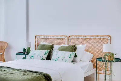 a bedroom with a white bed with green pillows at Brisa Algarvia 1 in Faro