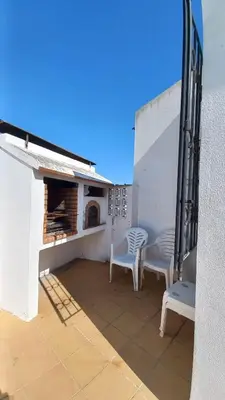 a patio with two chairs and a pizza oven at Villa UM in Albufeira