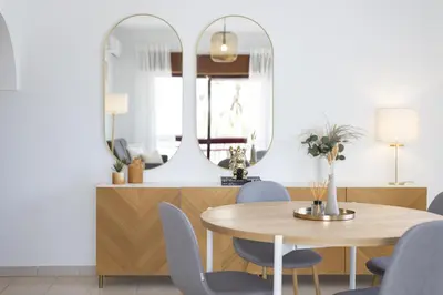a dining room with a table and chairs and a mirror at Mare Viva - Seafront with pool by HD in Quarteira