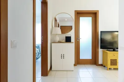 a hallway with a white cabinet and a mirror at 1 Bedroom apt with pool access in Albufeira