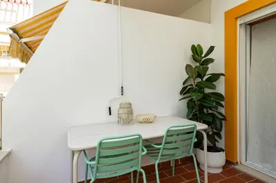a dining room with a white table and two chairs at 1 Bedroom apt with pool access in Albufeira