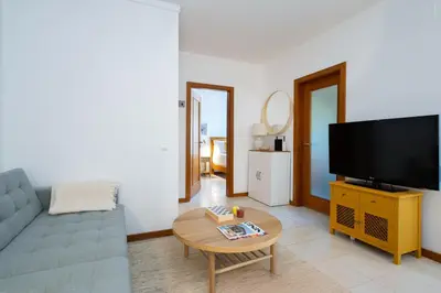 a living room with a couch and a tv at 1 Bedroom apt with pool access in Albufeira