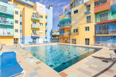 a swimming pool in front of two apartment buildings at Marina Paradis Bleu in Albufeira