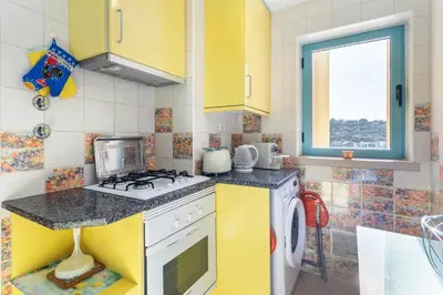 a kitchen with yellow cabinets and a stove at Marina Paradis Bleu in Albufeira