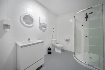 a white bathroom with a sink and a toilet at Plaza Inn Hostel & Rooms in Faro