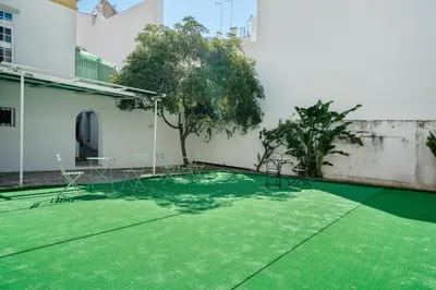 a courtyard of a building with a green lawn at Plaza Inn Hostel & Rooms in Faro
