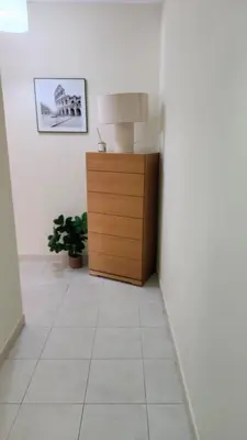 a hallway with a lamp and a dresser in a room at Vista das Ondas in Albufeira