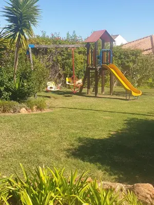a playground with a slide in a yard at Vista das Ondas in Albufeira