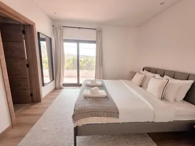 a bedroom with a large bed and a large window at Casa Shiva in Albufeira