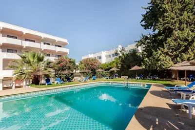 a swimming pool in front of a hotel at 1- bedroom flat in Vilamoura near the beach in Vilamoura