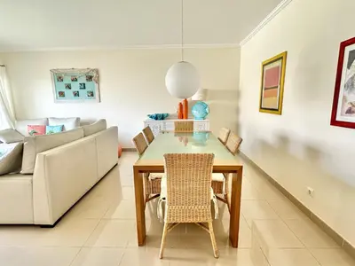 a living room with a table and a couch at Apartamento 10 min da praia in Albufeira