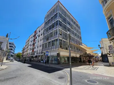 a tall glass building on a city street at Blife Lusitanya - private rooms at Santantonya 1st floor in Faro