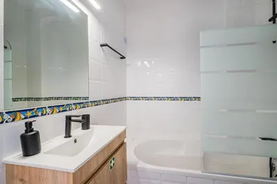 a white bathroom with a sink and a bath tub at Casa Gale Mar in Galé