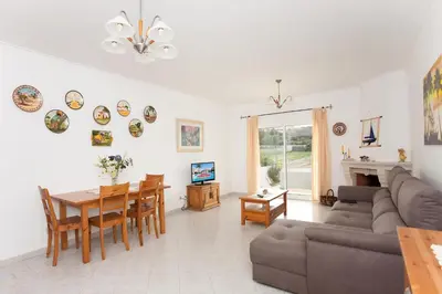 a living room with a couch and a table at Os Apartamentos A Ramos na Praia da Galé Estão inserido em Condomínio com PISCINA, Fica apenas a 350 Metros da Praia da Galé - Apartamentos com Ar Condicionado tanto nos Quartos como na Sala, Smart TV com Prime Vídeo e Cozinha Completa in Albufeira