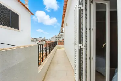 a bedroom with a large white bed and a window at T2 Apartment near the beach in Albufeira