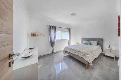 a white bedroom with a bed and a window at Quinta Veigas in Medronhal