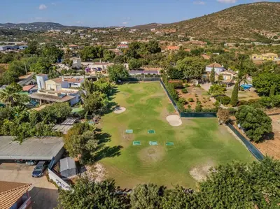 an aerial view of a golf course with trees and houses at Quinta Veigas in Medronhal