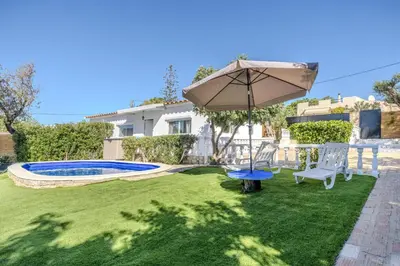 a yard with an umbrella and a pool at Quinta Veigas in Medronhal