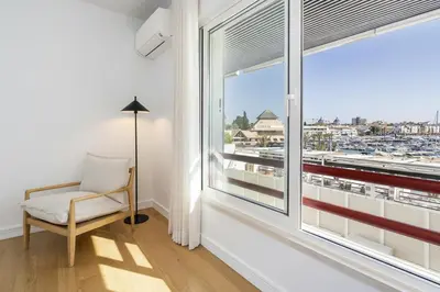 a room with a chair and a window with a view at Vilamarina Elegance T2 Marina View Vilamoura in Quarteira