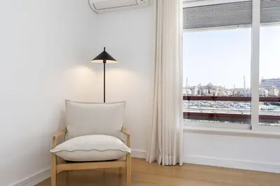 a white chair in a room with a window at Vilamarina Elegance T2 Marina View Vilamoura in Quarteira