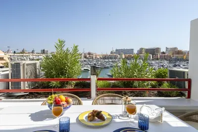 a table with a bowl of fruit on a balcony at Vilamarina Elegance T2 Marina View Vilamoura in Quarteira
