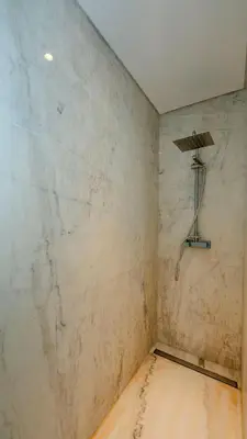 a shower in a room with a marble wall at Central Vilamoura Casa A in Quarteira
