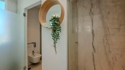 a bathroom with a toilet and areath on the wall at Central Vilamoura Casa A in Quarteira