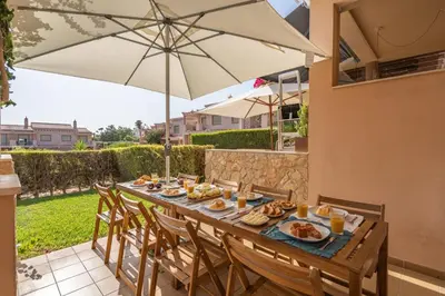 a table with food and an umbrella on a patio at Sunny House with Jacuzzi and Pool by HostWise in Albufeira