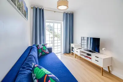 a living room with a blue couch and a tv at Charming Old Town 1BR 50m from Beach AC Wi-Fi Parking in Albufeira