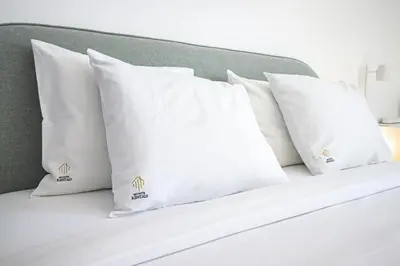 a group of white pillows on a bed at Charming Old Town 1BR 50m from Beach AC Wi-Fi Parking in Albufeira