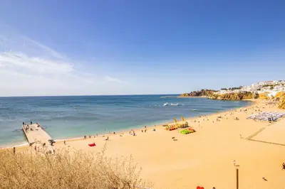 a group of people on a beach with the ocean at Charming Old Town 1BR 50m from Beach AC Wi-Fi Parking in Albufeira