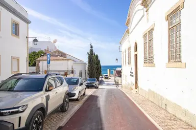 a street with cars parked on the side of the road at Charming Old Town 1BR 50m from Beach AC Wi-Fi Parking in Albufeira