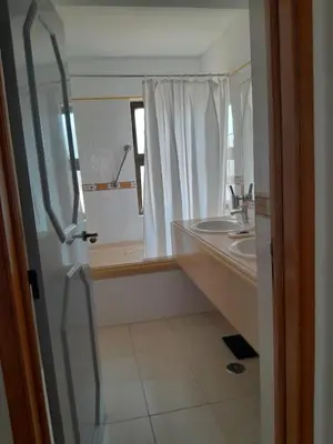 a bathroom with a sink and a shower and a mirror at FourSeasons Vilamoura in Quarteira