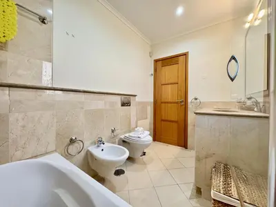 a bathroom with a tub and a toilet and a sink at Vilamoura Victoria Boulevard With Pool by Homing in Vilamoura