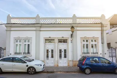 two cars parked in front of a white building at Blife Galya private house in Faro