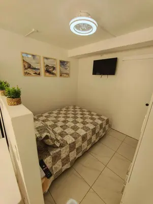 a bedroom with a bed and a flat screen tv at Santos Studio in Faro