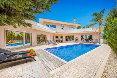 a villa with a swimming pool and a house at Villa Caripira by Villa Plus in Albufeira