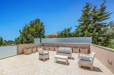 a patio with chairs and tables on a roof at Villa Caripira by Villa Plus in Albufeira